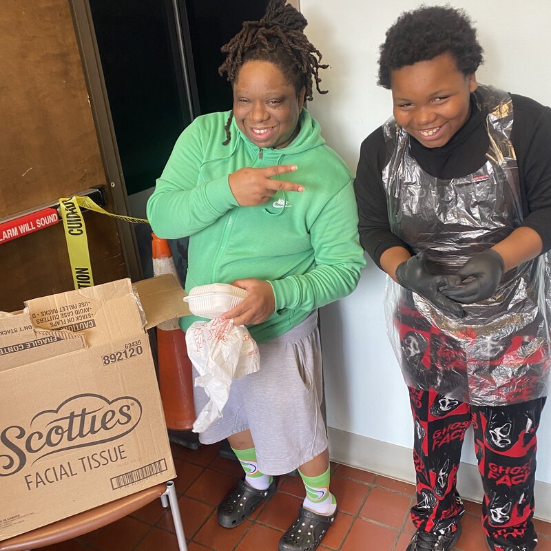 Heavy HeartZ volunteers smiling while packing meal donations