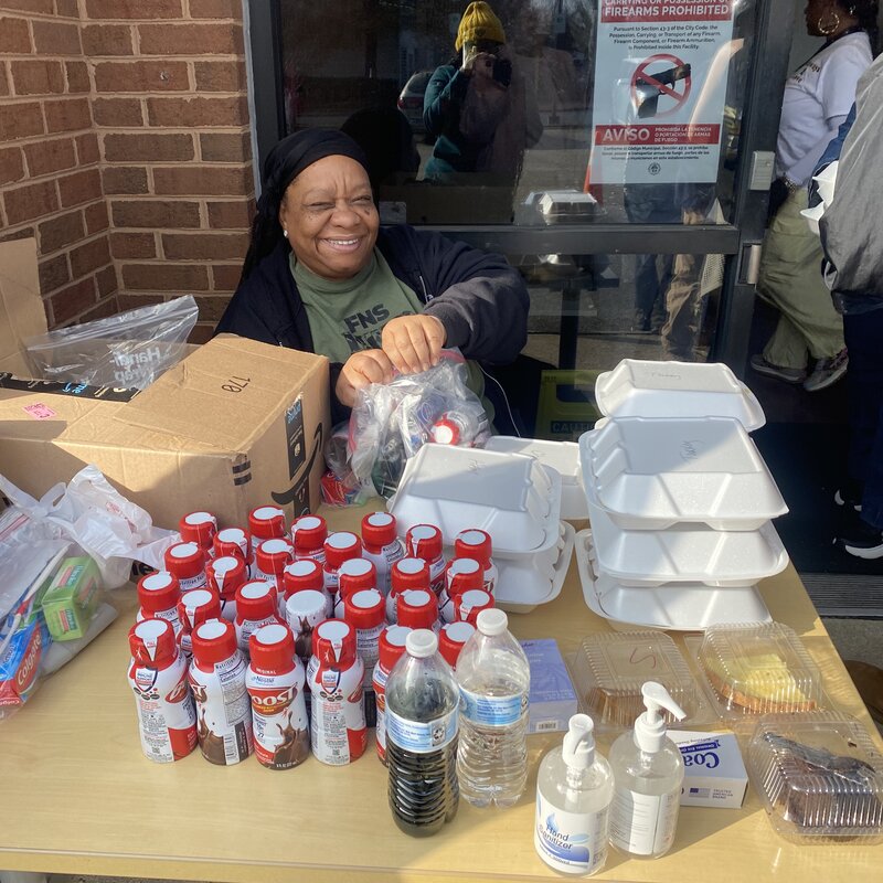 Heavy HeartZ volunteer handing out supplies at an outreach table